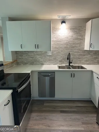 a kitchen with stainless steel appliances granite countertop a sink stove and cabinets