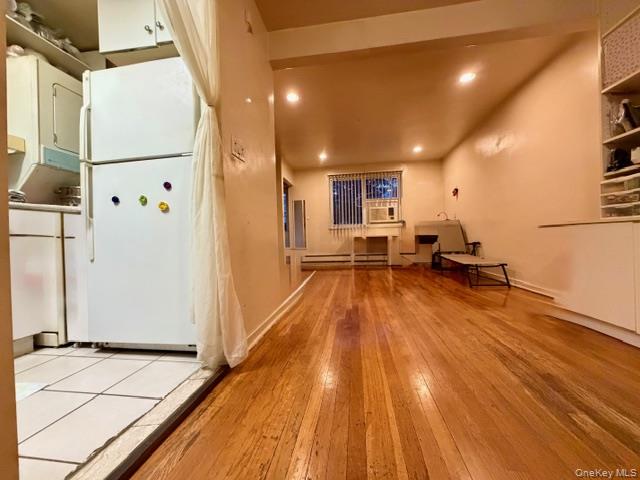 220-34 67th Avenue, Unit 2LEVELS Queens, NY 11364 - Photo 9 of 30 Kitchen featuring freestanding refrigerator, recessed lighting, light wood finished floors, white cabinets, and baseboard heating