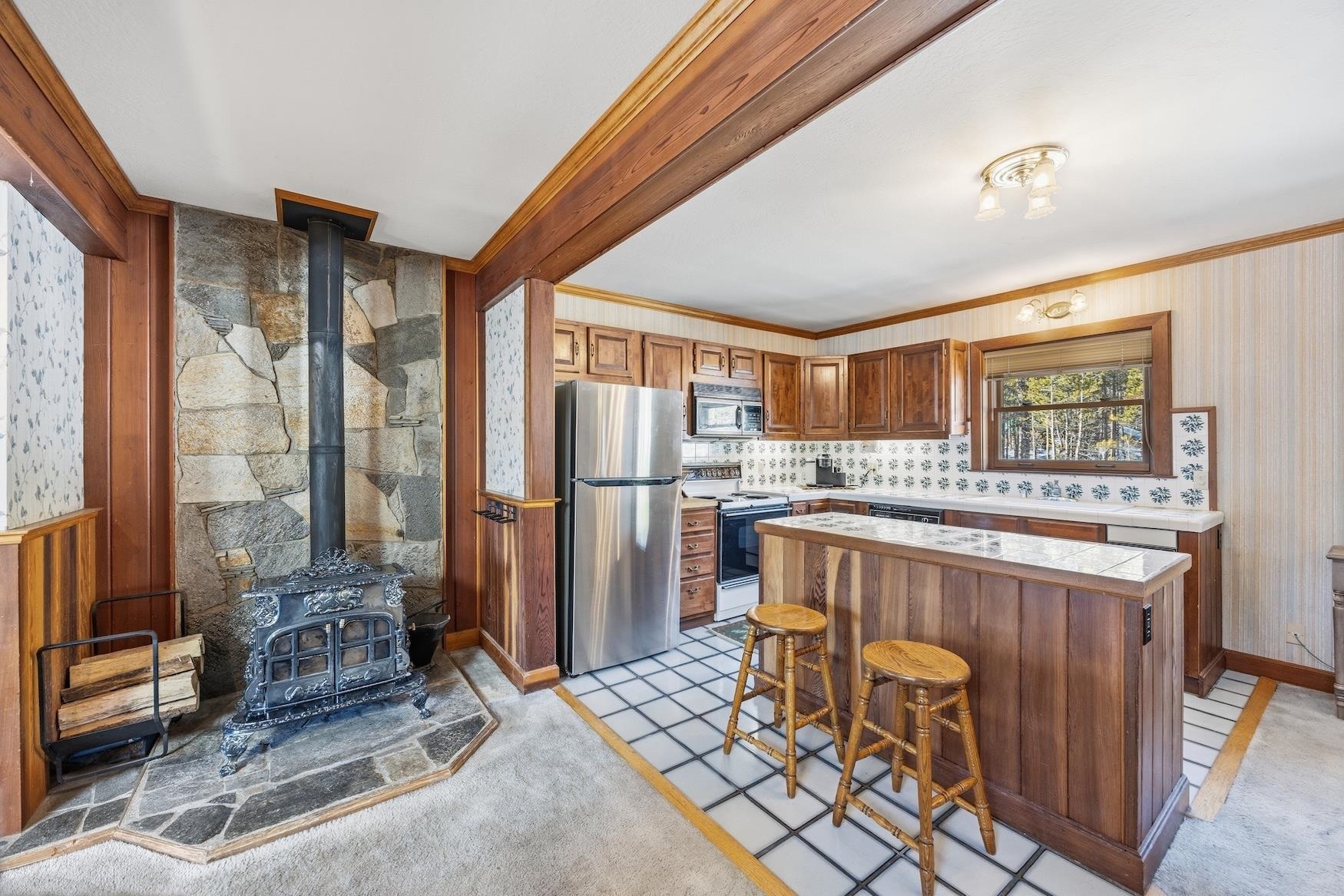 21501 Donner Pass Road, Unit 13 Soda Springs, CA 95728 - Photo 6 of 23 a kitchen with stainless steel appliances kitchen island granite countertop a refrigerator and a stove