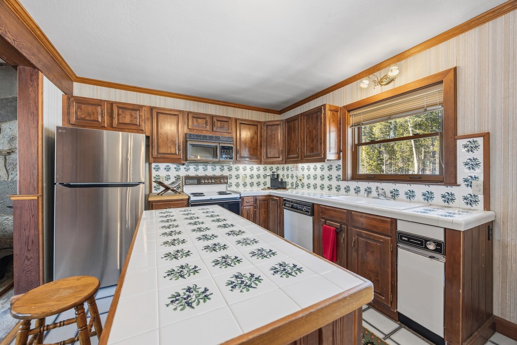 21501 Donner Pass Road, Unit 13 Soda Springs, CA 95728 - Photo 8 of 23 a kitchen with stainless steel appliances granite countertop a refrigerator and a stove top oven