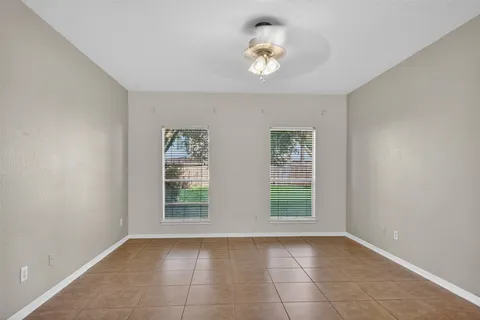 an empty room with a window and ceiling fan