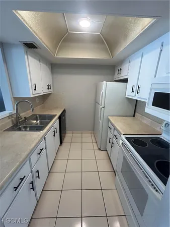 a kitchen with granite countertop a stove a sink and a refrigerator