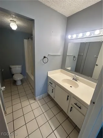 a spacious bathroom with a double vanity sink toilet and a mirror