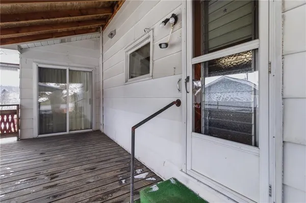 a view of a hallway with wooden floor and entryway