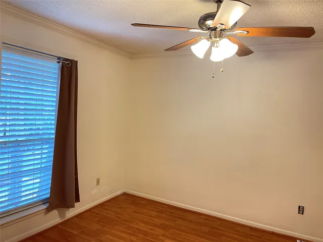 a view of a room with wooden floor and fan