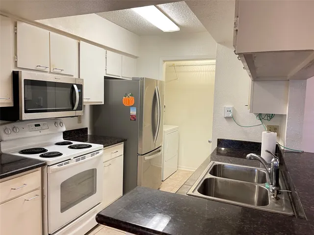 a kitchen with stainless steel appliances a stove a microwave and a refrigerator