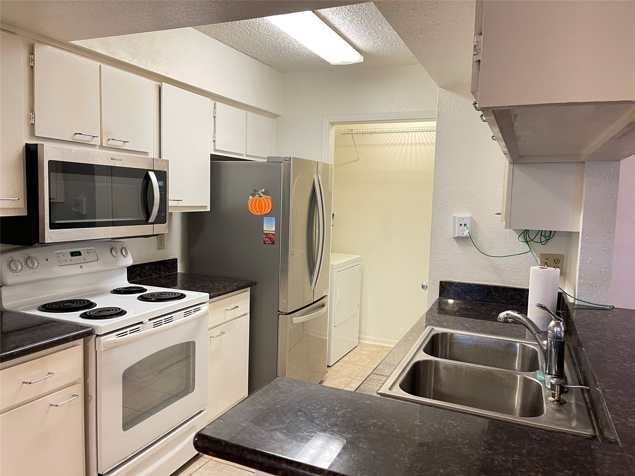 2800 Jeanetta Street, Unit 2204 Houston, TX 77063 - Photo 6 of 28 a kitchen with stainless steel appliances a stove a microwave and a refrigerator