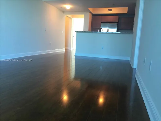 a view of a room with wooden floor and a window