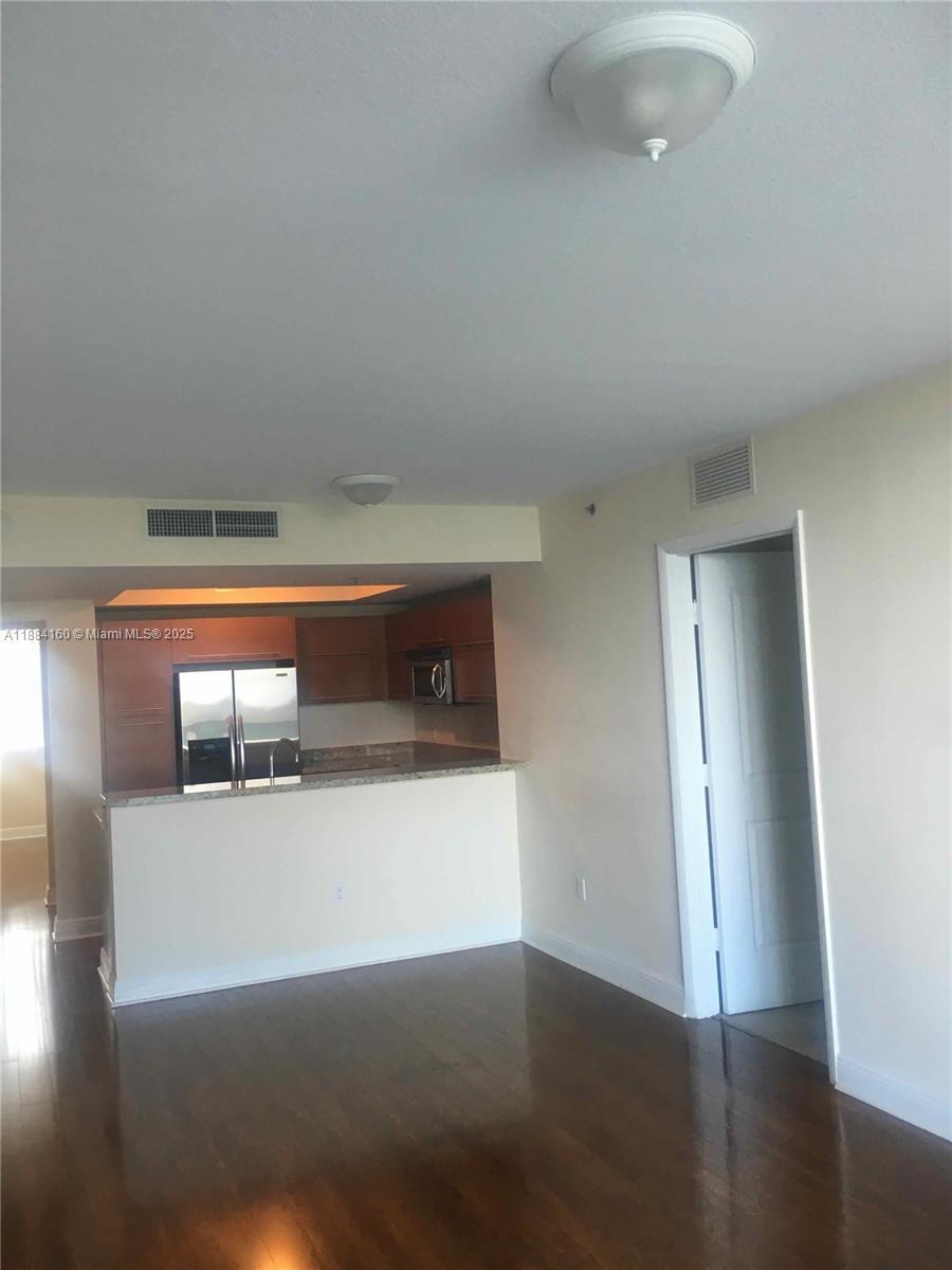 2641 North Flamingo Road, Unit 1705N Sunrise, FL 33323 - Photo 9 of 56 an empty room with wooden floor and windows