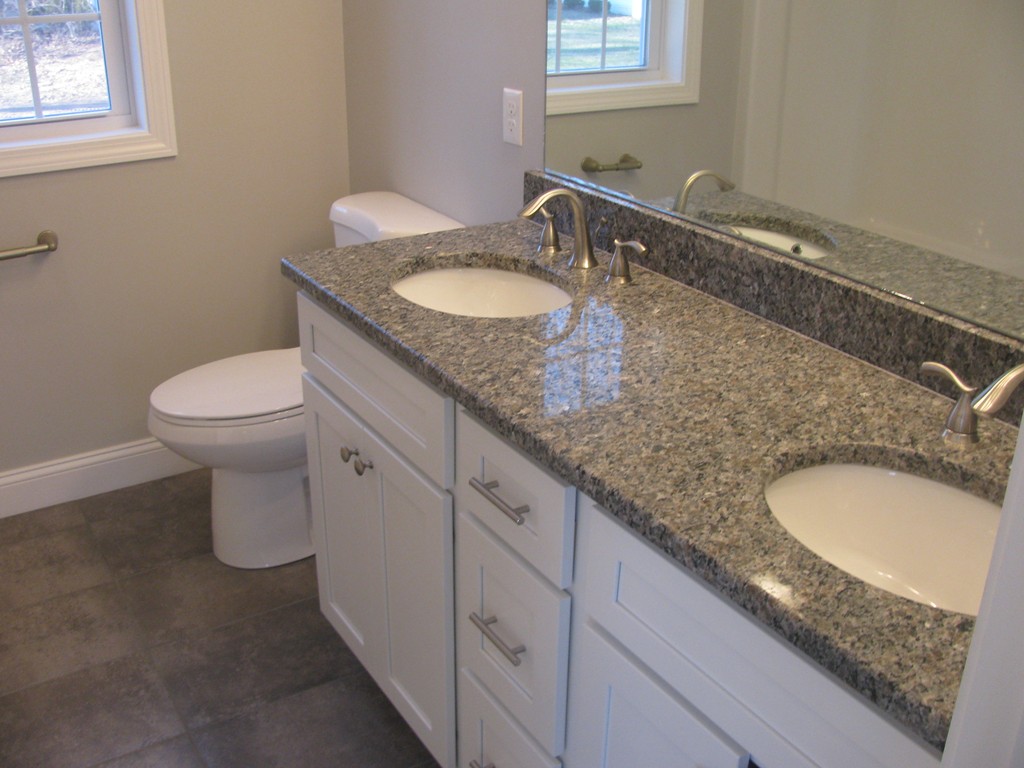 132 Tiffany Street Springfield, MA 01108 - Photo 13 of 18 a bathroom with a granite countertop sink a toilet and mirror
