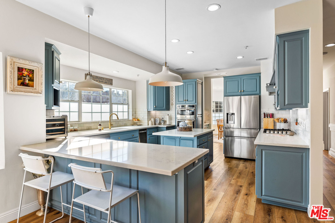 129 Saddlebow Road Bell Canyon, CA 91307 - Photo 4 of 39 a kitchen with refrigerator a stove and chairs
