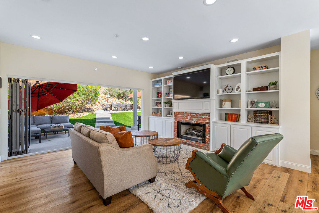 129 Saddlebow Road Bell Canyon, CA 91307 - Photo 7 of 39 a living room with fireplace furniture and a flat screen tv