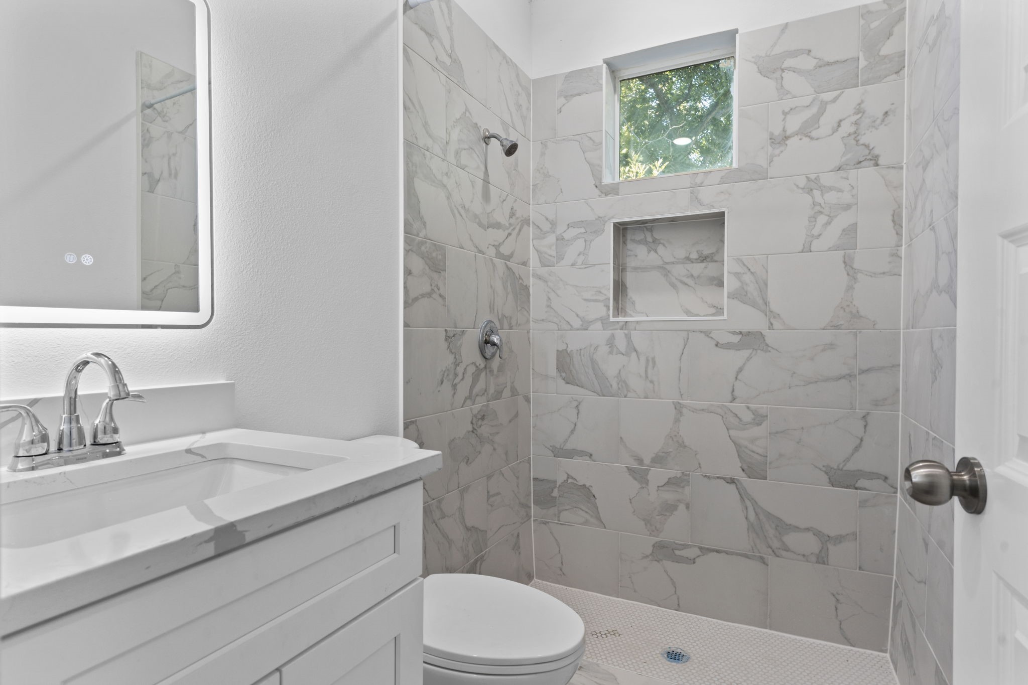 4017 Ward Street Houston, TX 77021 - Photo 19 of 45 Sleek bathroom with a frameless walk-in shower and LED-lit mirror.