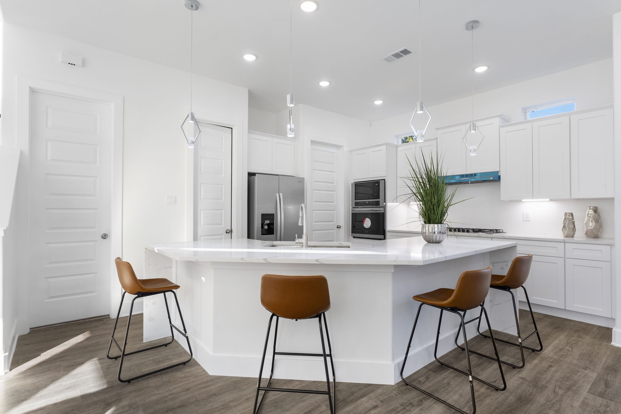 4017 Ward Street Houston, TX 77021 - Photo 7 of 45 Modern kitchen featuring a spacious island, quartz countertops, built-in appliances, and stylish pendant lighting.
