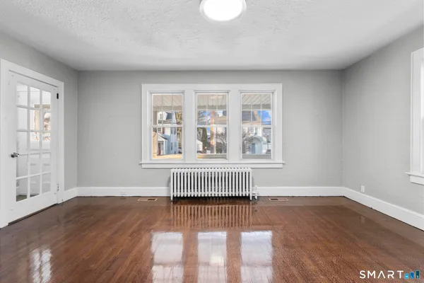 an empty room with wooden floor and windows