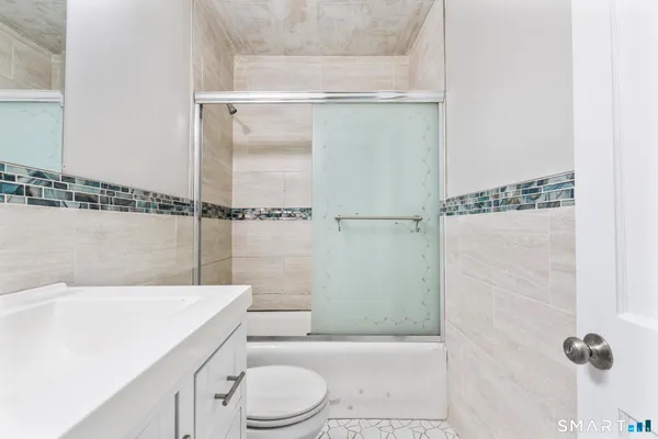 a bathroom with a shower a toilet and sink