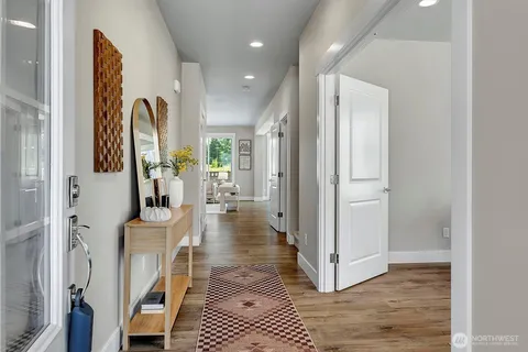a view of a hallway with wooden floor and windows