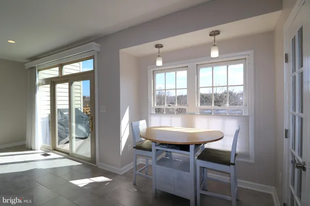 a dining room with wooden floor a chandelier a glass table and chairs