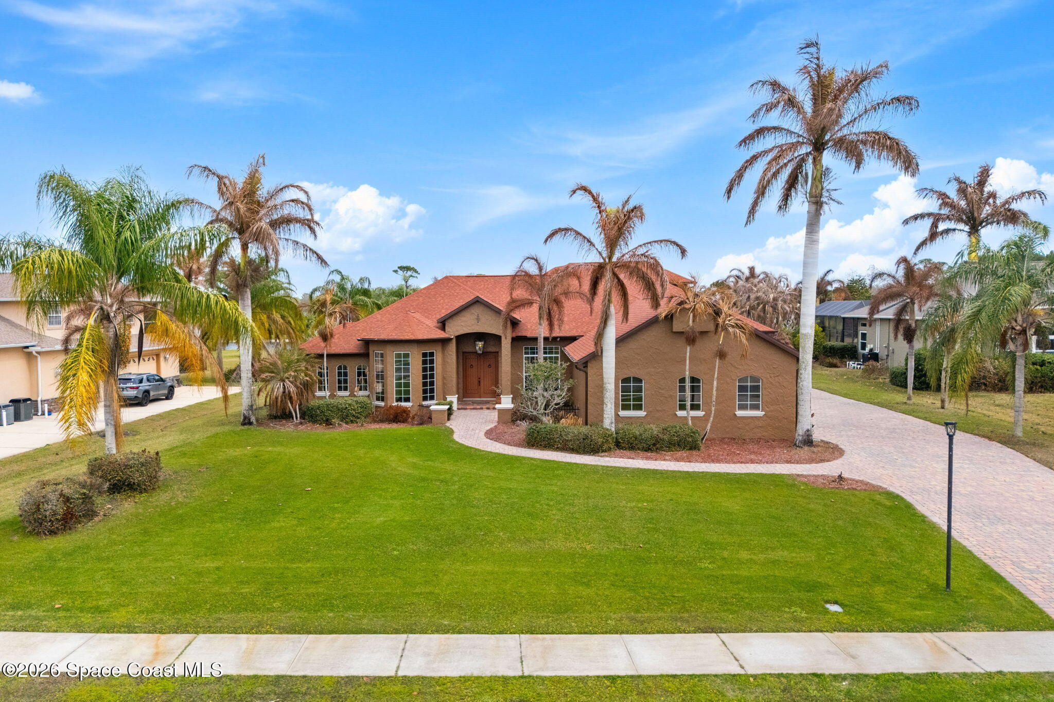 5137 Royal Paddock Way Merritt Island, FL 32953 - Photo 120 of 132 a front view of a house with a garden and palm trees