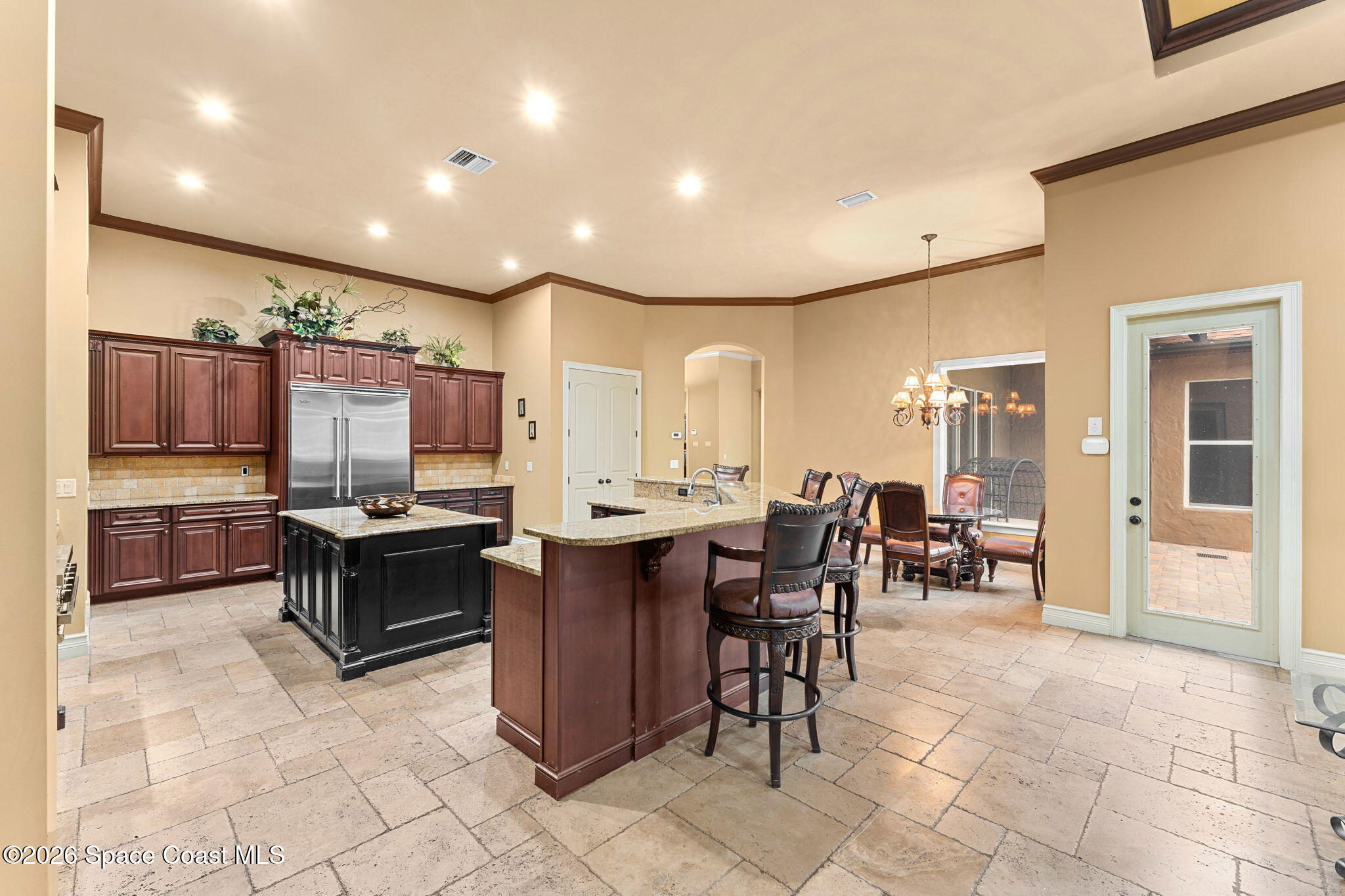 5137 Royal Paddock Way Merritt Island, FL 32953 - Photo 28 of 132 a kitchen with stainless steel appliances kitchen island granite countertop a table and chairs in it