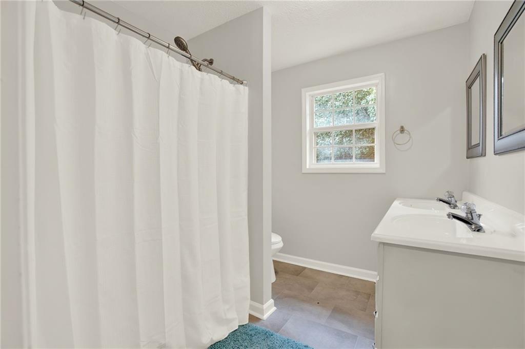 76 Picklesimer Road Southwest Cartersville, GA 30120 - Photo 18 of 43 a bathroom with a sink a mirror and a shower curtain