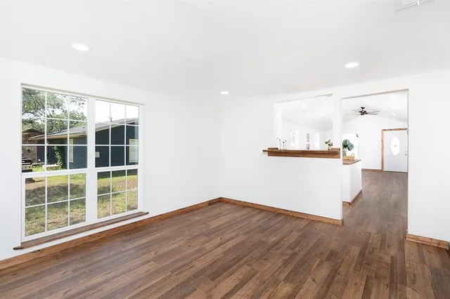 a view of empty room with wooden floor and window