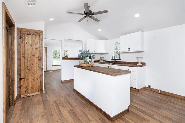 a kitchen with stainless steel appliances a refrigerator a sink dishwasher and a stove top oven with wooden floor