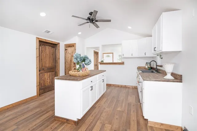 a kitchen with granite countertop a sink appliances cabinets and wooden floor