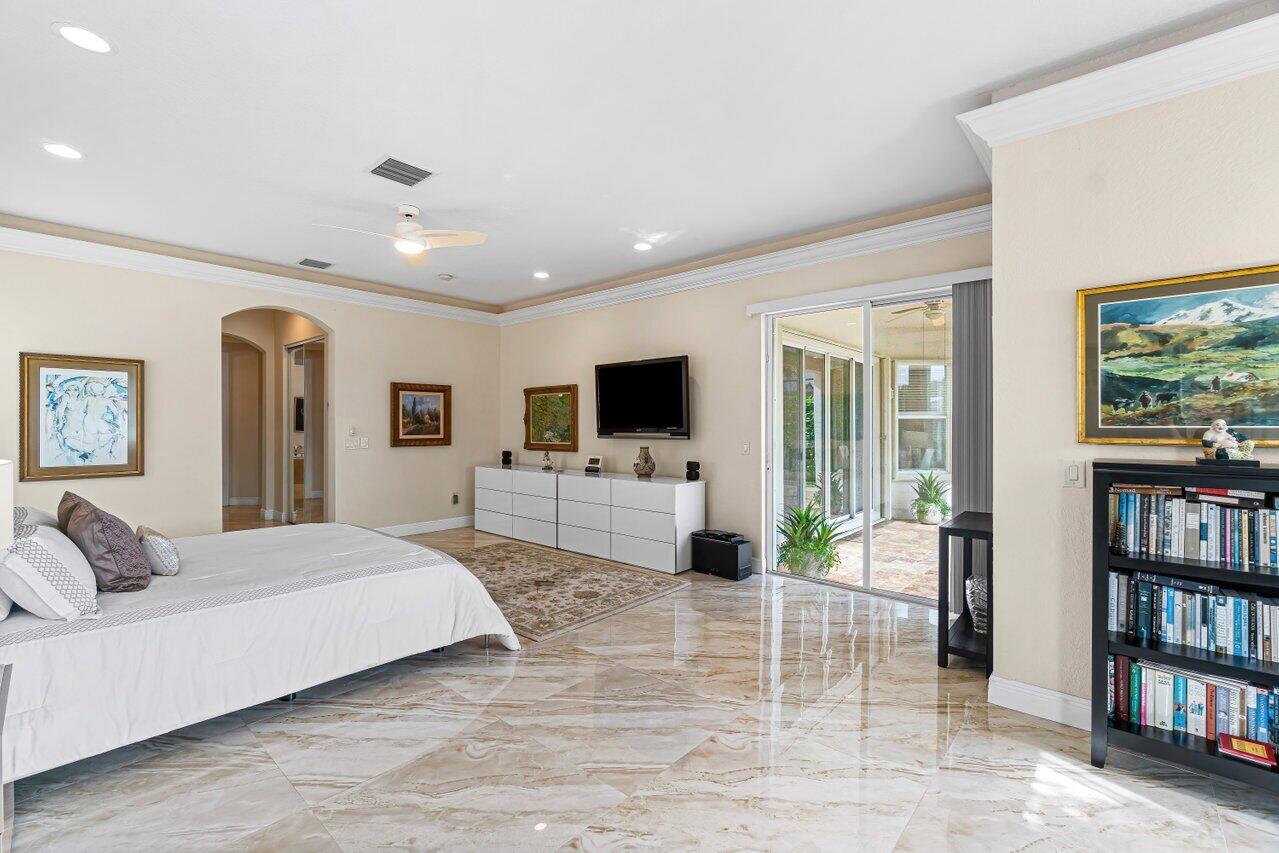 10822 Sunset Ridge Circle Boynton Beach, FL 33473 - Photo 24 of 99 a bedroom with a large bed and a flat screen tv