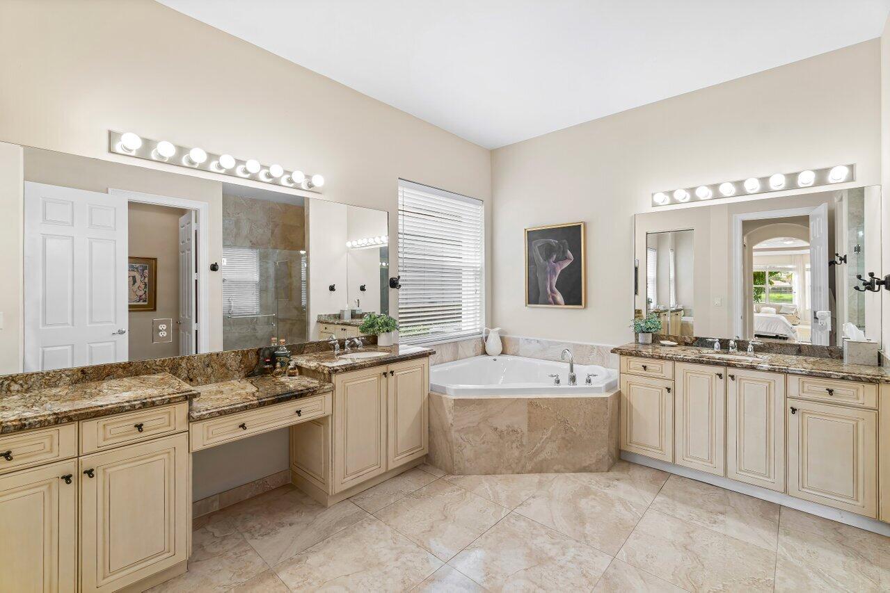 10822 Sunset Ridge Circle Boynton Beach, FL 33473 - Photo 26 of 99 a large bathroom with a double vanity sink large mirror and a bathtub