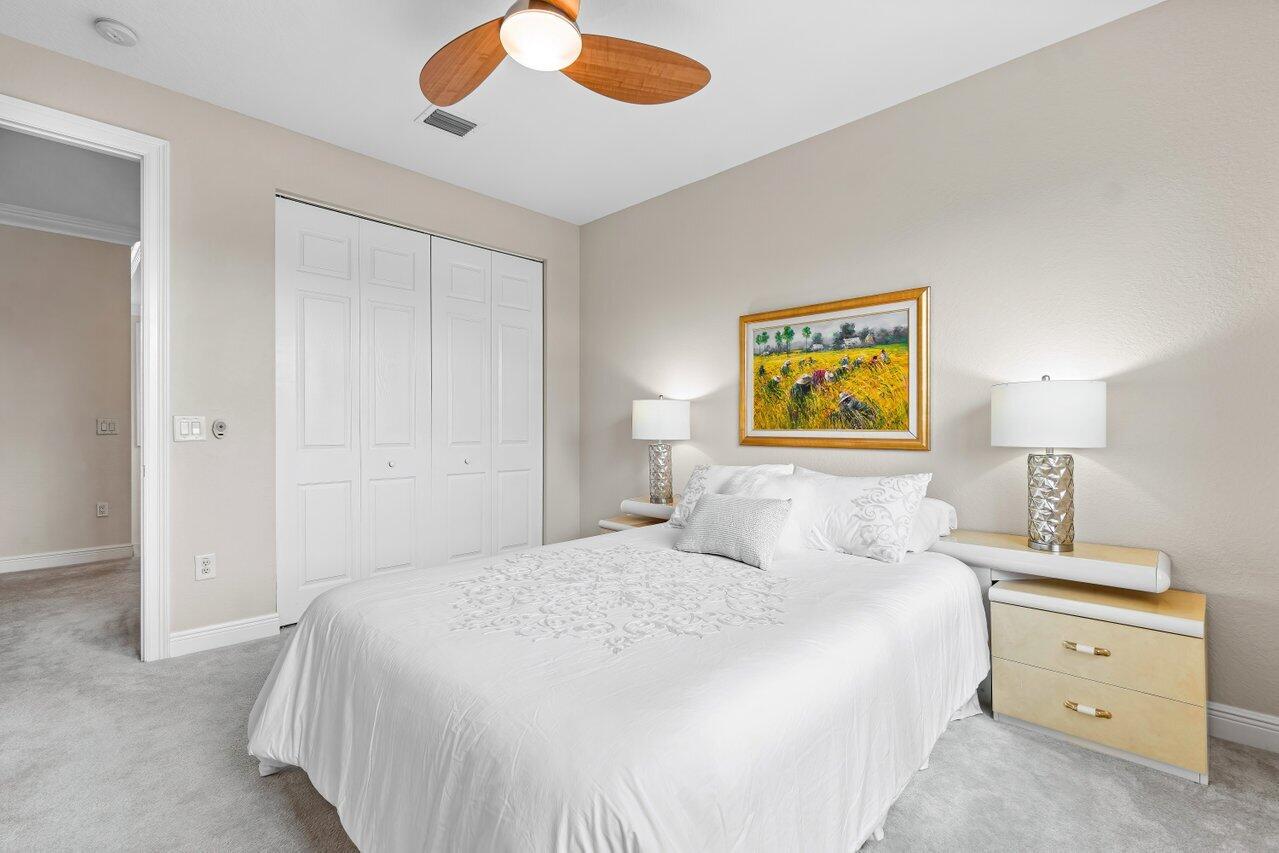 10822 Sunset Ridge Circle Boynton Beach, FL 33473 - Photo 39 of 99 a bedroom with a bed and a lamp on dresser