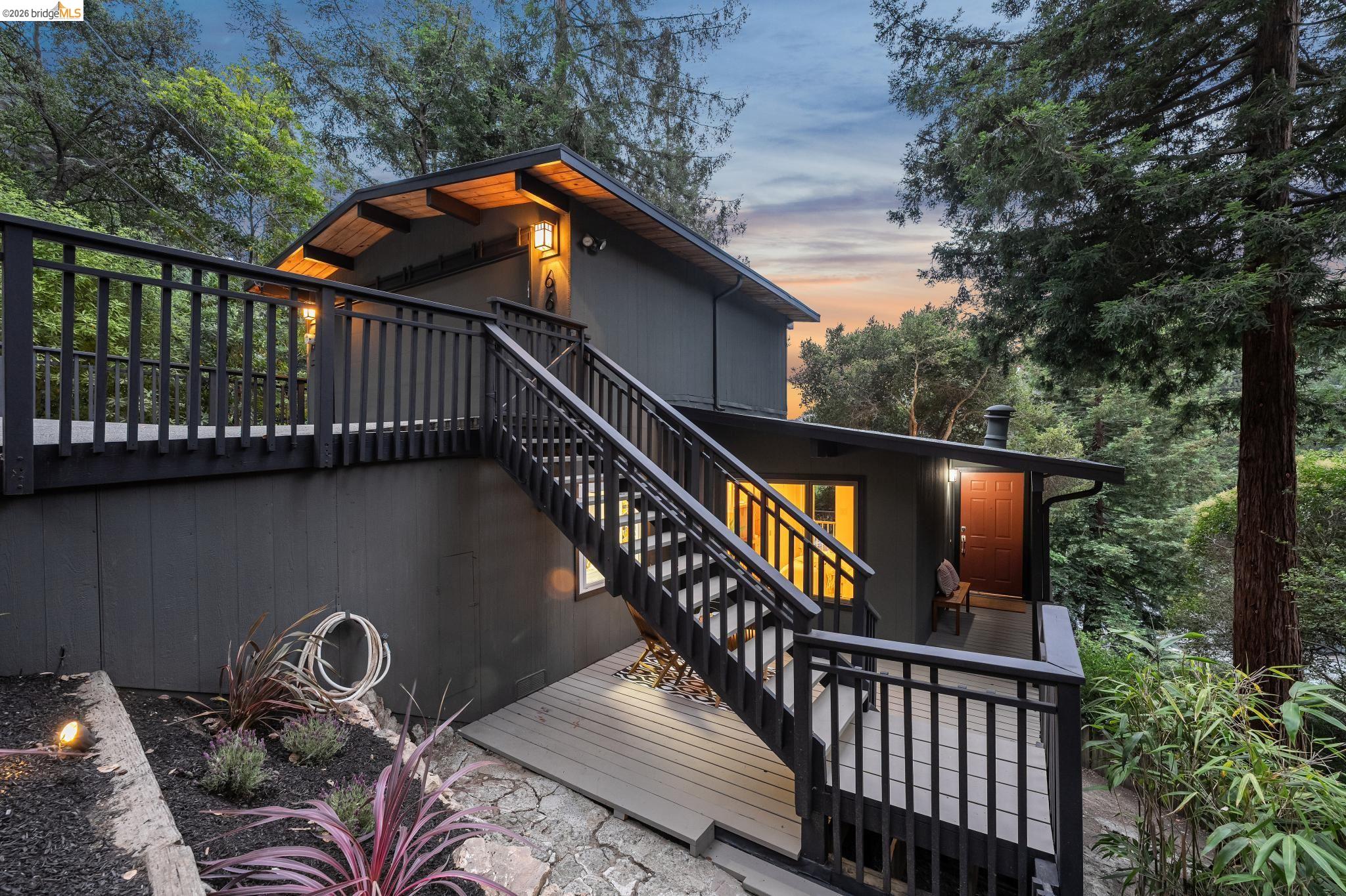 6645 Heather Ridge Way Oakland, CA 94611 - Photo 9 of 61 Multi-level exterior featuring dark siding, exposed wood eaves, and a covered entryway