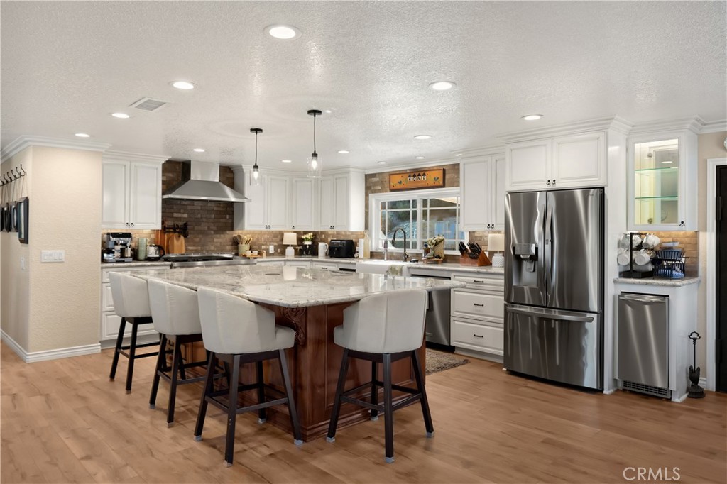 3070 Lytle Creek Road Lytle Creek, CA 92358 - Photo 15 of 68 a kitchen with stainless steel appliances granite countertop a dining table chairs refrigerator and sink