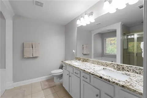 a bathroom with a granite countertop sink a toilet and a mirror
