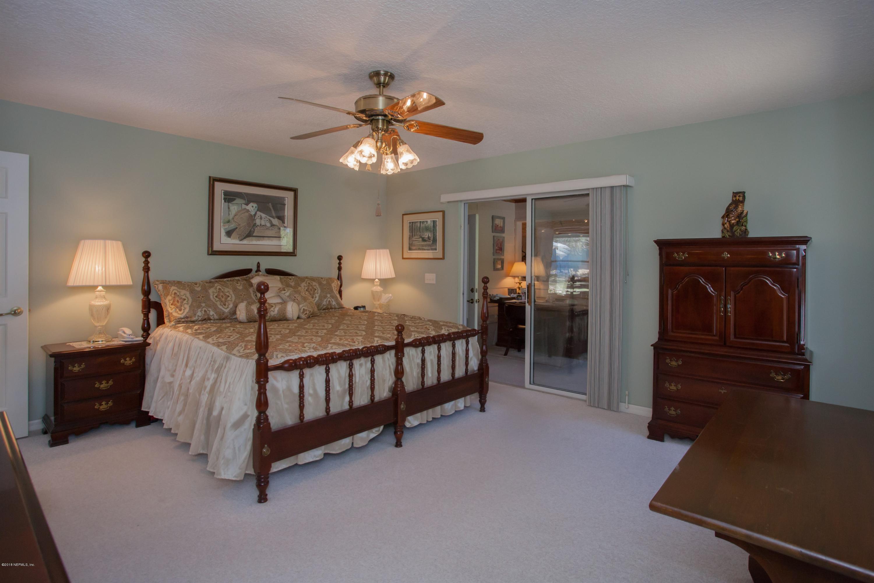7986 National Forest Road Palatka, FL 32177 - Photo 18 of 31 a bedroom with a bed and a chandelier