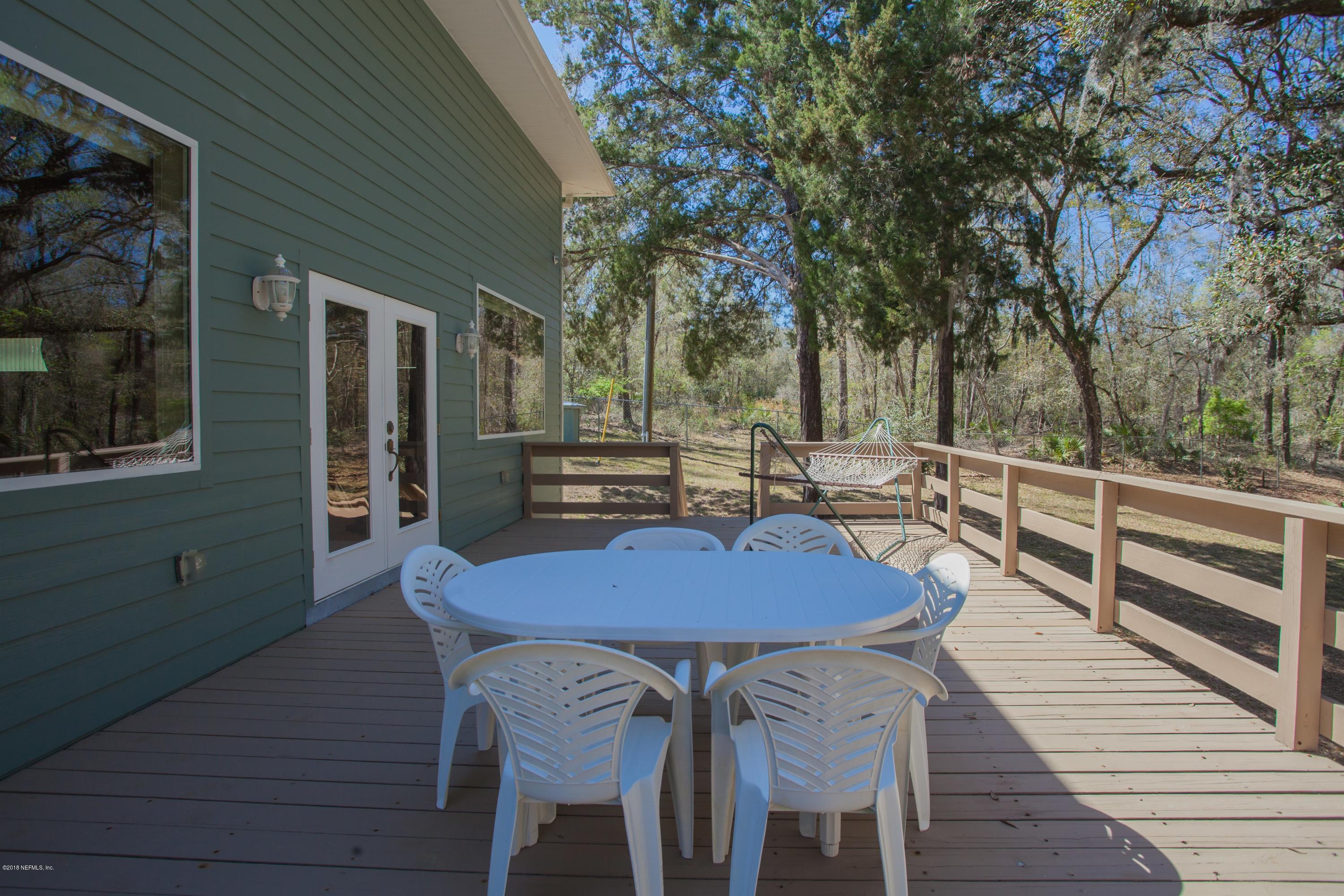 7986 National Forest Road Palatka, FL 32177 - Photo 24 of 31 a view of a patio with table and chairs with wooden floor and fence