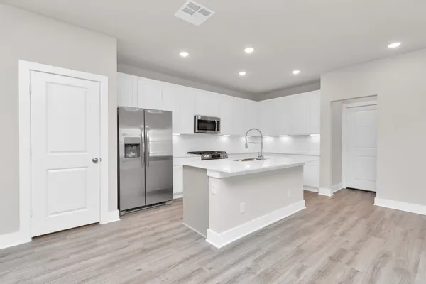 a kitchen with stainless steel appliances a refrigerator sink and stove