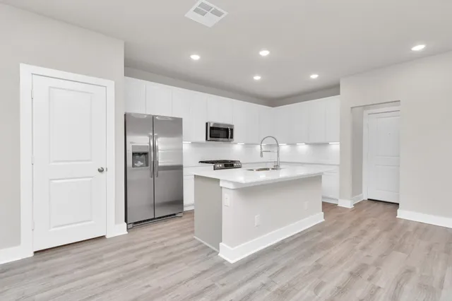a kitchen with stainless steel appliances a refrigerator sink and stove