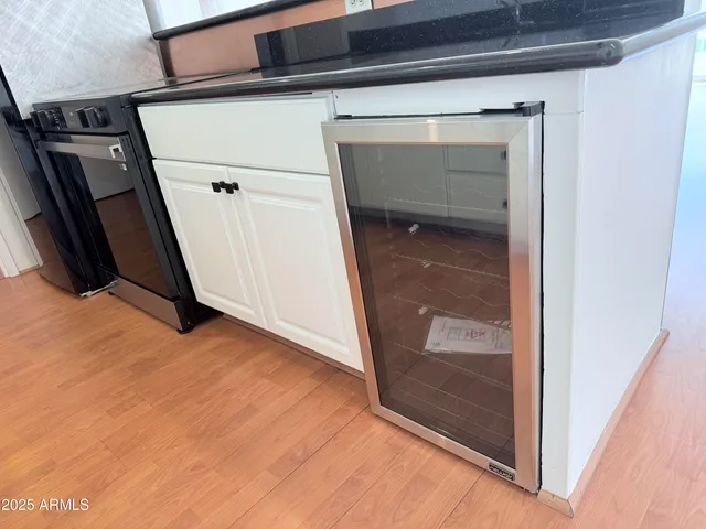 a kitchen with granite countertop white cabinets and refrigerator