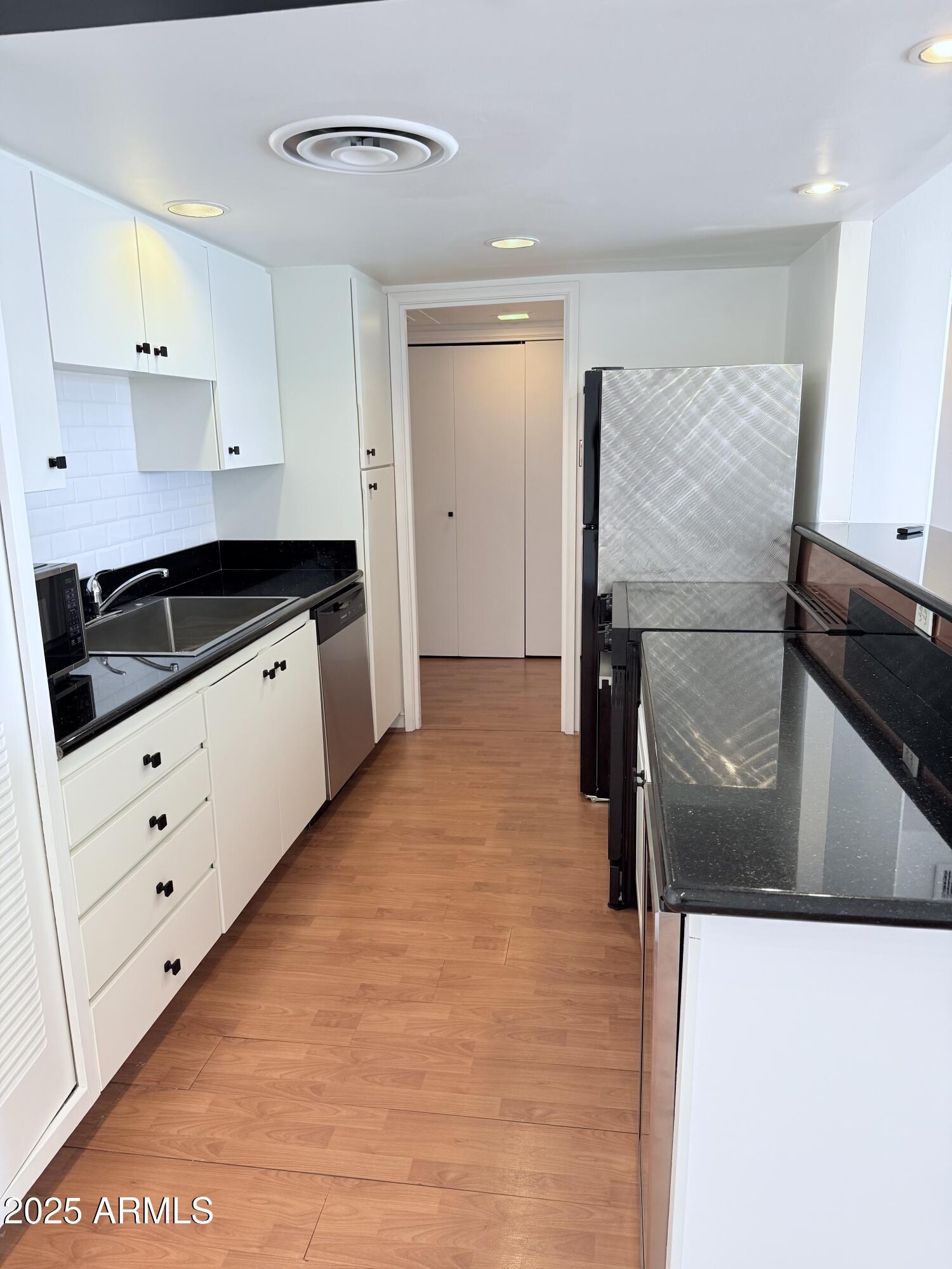 207 West Clarendon Avenue, Unit 4H Phoenix, AZ 85013 - Photo 21 of 37 a kitchen with granite countertop white cabinets and refrigerator