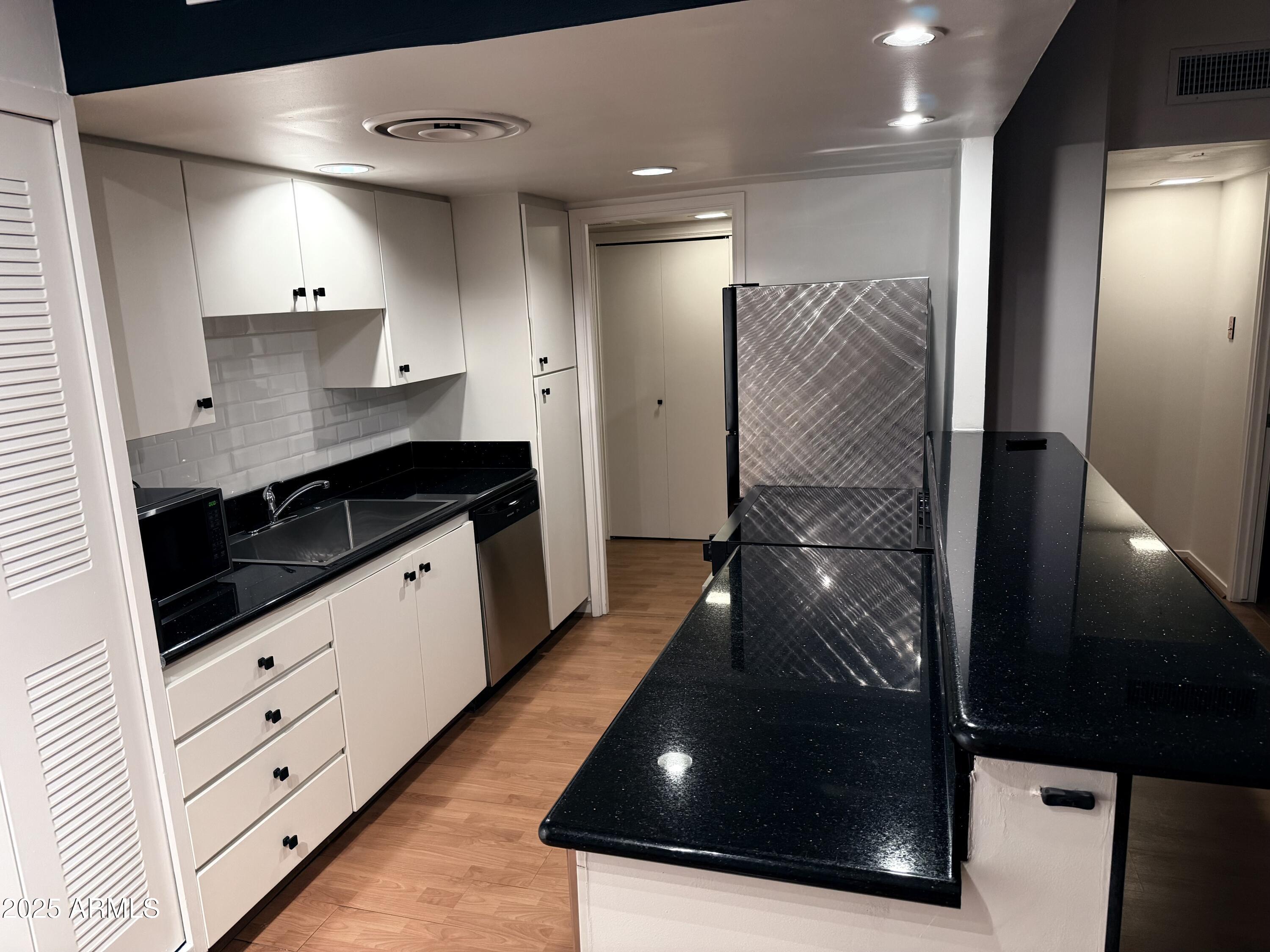 207 West Clarendon Avenue, Unit 4H Phoenix, AZ 85013 - Photo 22 of 37 a kitchen with stainless steel appliances kitchen island granite countertop a stove a sink and a refrigerator