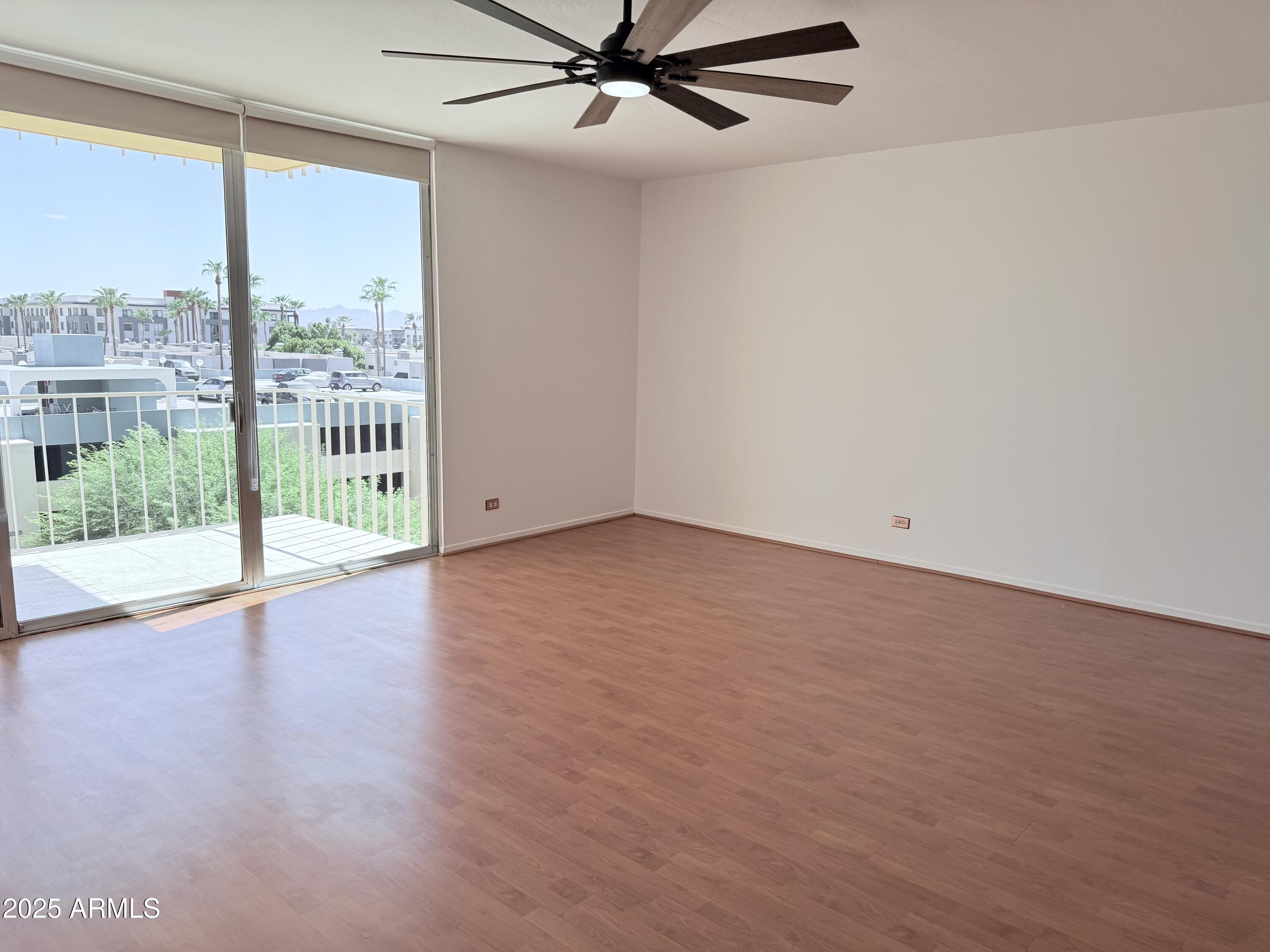 207 West Clarendon Avenue, Unit 4H Phoenix, AZ 85013 - Photo 26 of 37 an empty room with wooden floor and windows