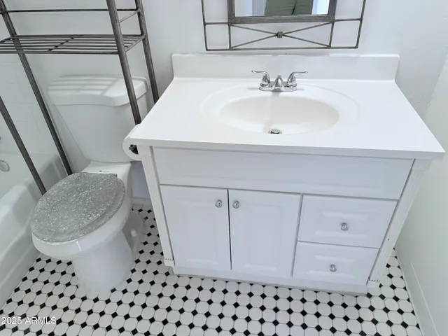 a bathroom with a sink toilet vanity and window