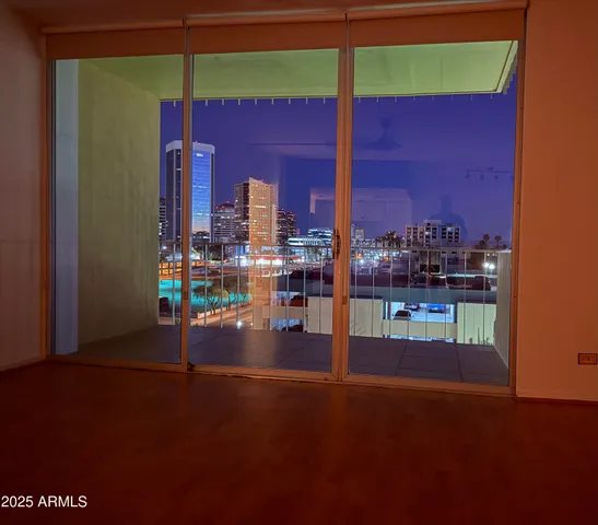 a living room with stainless steel appliances wooden floor and a table