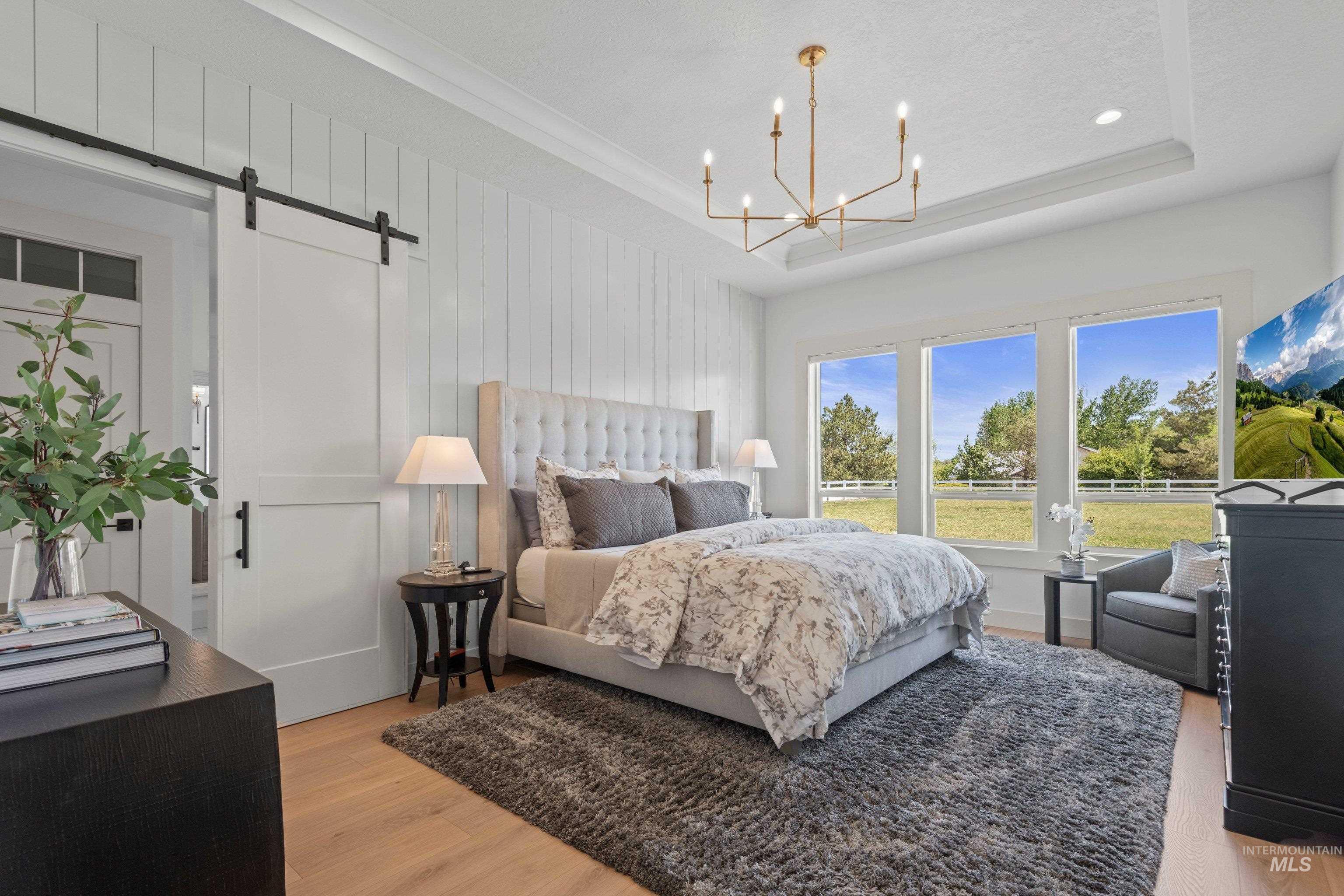 24990 Belgian Way Middleton, ID 83644 - Photo 22 of 50 Bedroom with wood-finish flooring, a tray ceiling, and a contemporary chandelier