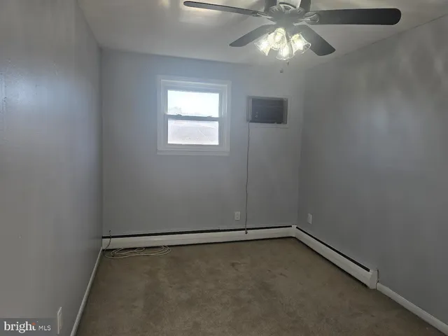 a view of an empty room with window and stairs
