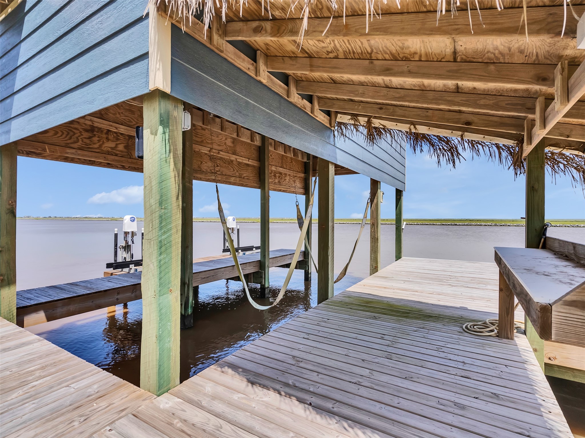 1453 County Road 230 Sargent, TX 77414 - Photo 29 of 38 Boat Lift — Enjoy the ultimate coastal living with an outdoor shower with hot and cold running water, a convenient fish-cleaning station, boat lift, and dual Jet Ski lifts.