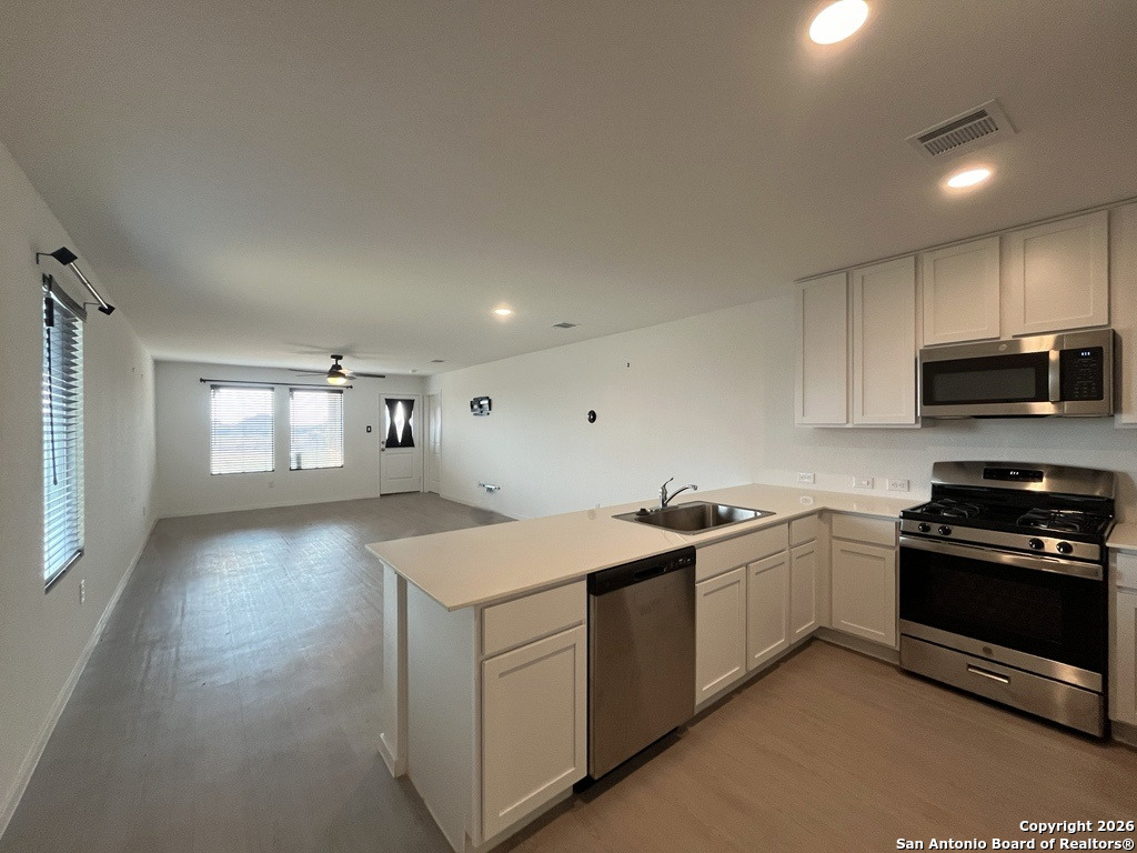 248 Cowboy Ridge Pleasanton, TX 78064 - Photo 8 of 37 a kitchen that has a sink and a stove in it