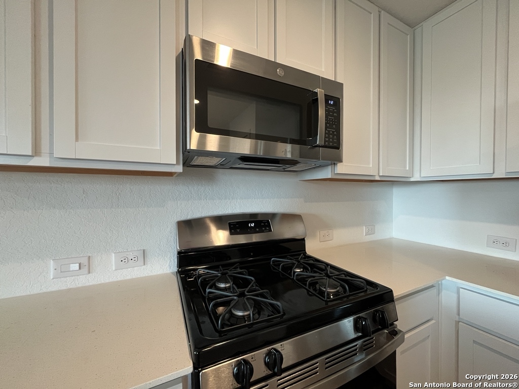 248 Cowboy Ridge Pleasanton, TX 78064 - Photo 10 of 37 a kitchen with a stove and a microwave
