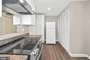 a kitchen with granite countertop a sink a stove and refrigerator